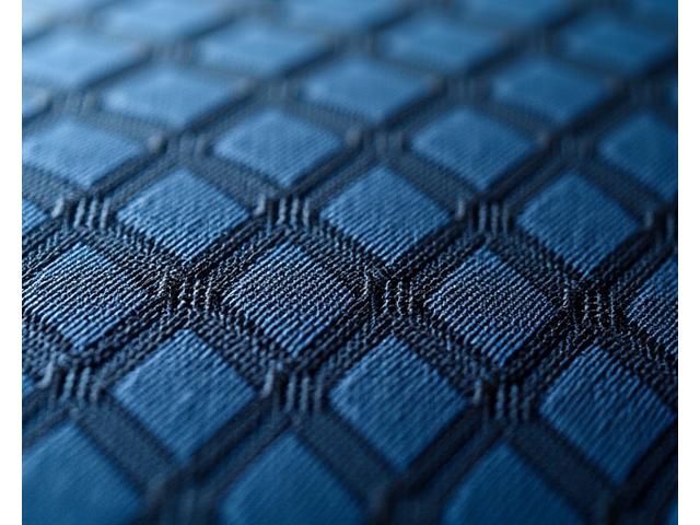 Nærbilde av et slitesterkt møbelstoff med et intrikat geometrisk vevemønster